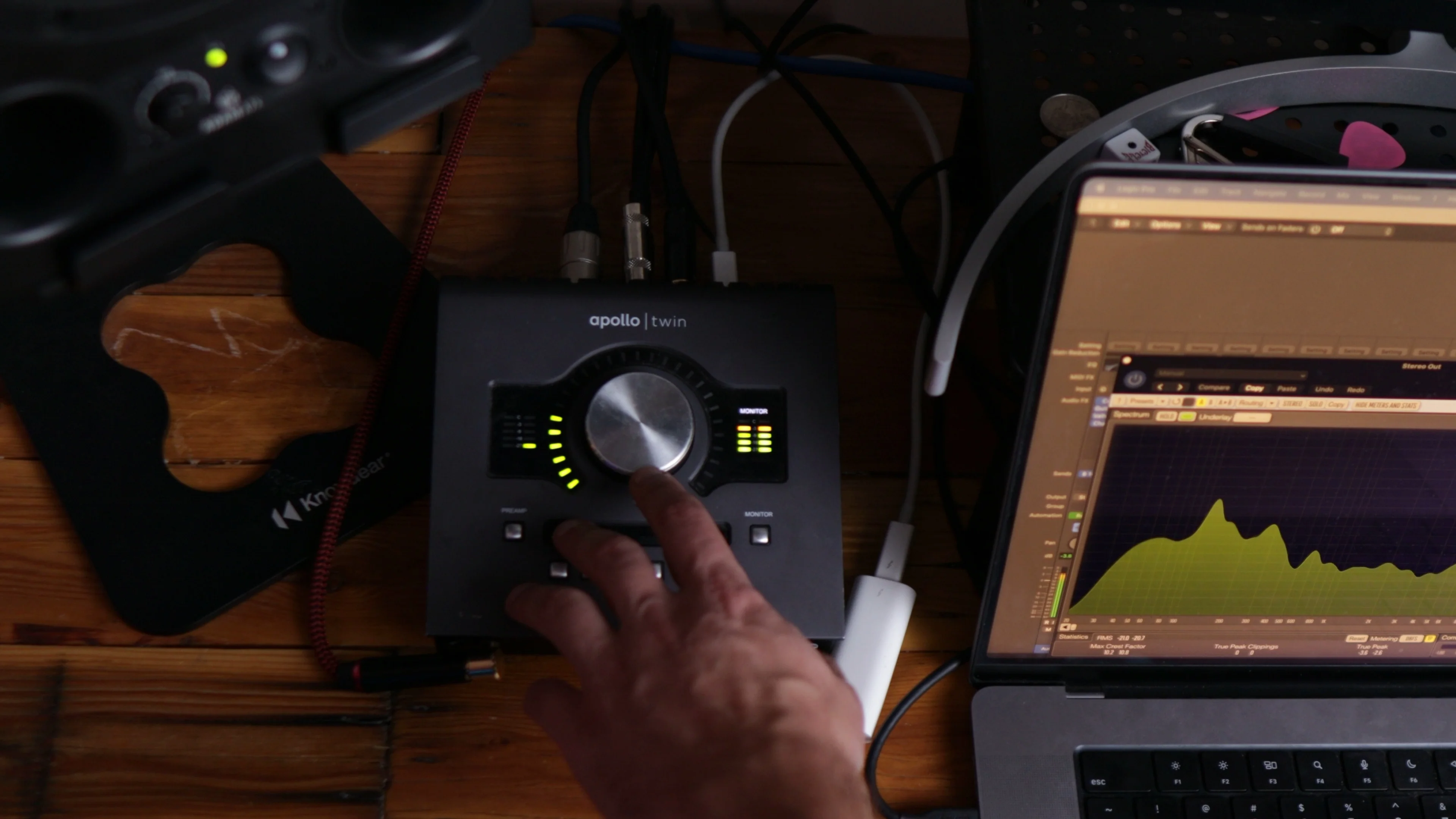 Hand adjusting input levels on Universal Audio Apollo Twin interface to optimize signal-to-noise ratio before applying noise gate