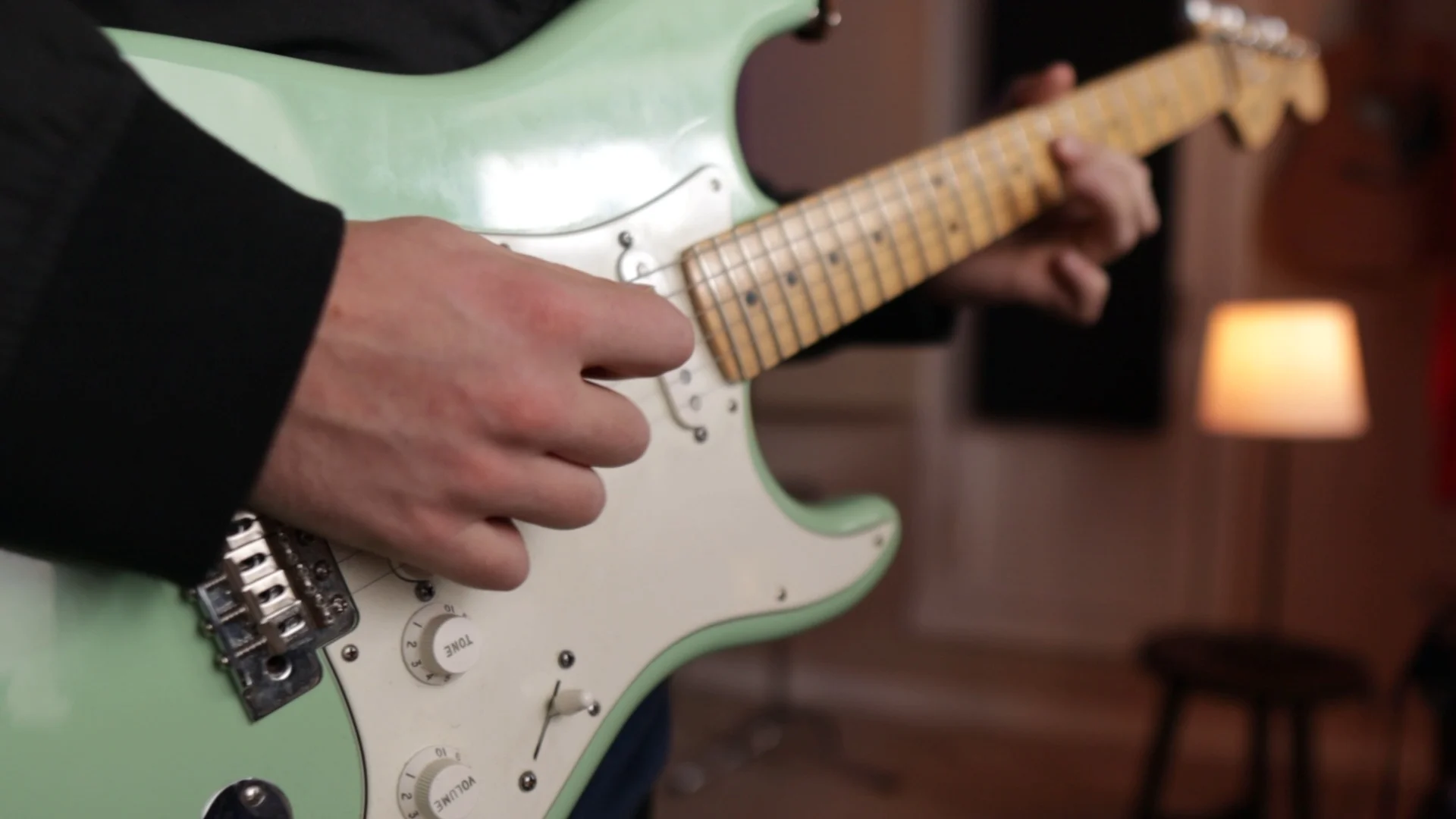 Close-up of electric guitar being played, demonstrating instrumental arrangement techniques that support vocal mixing