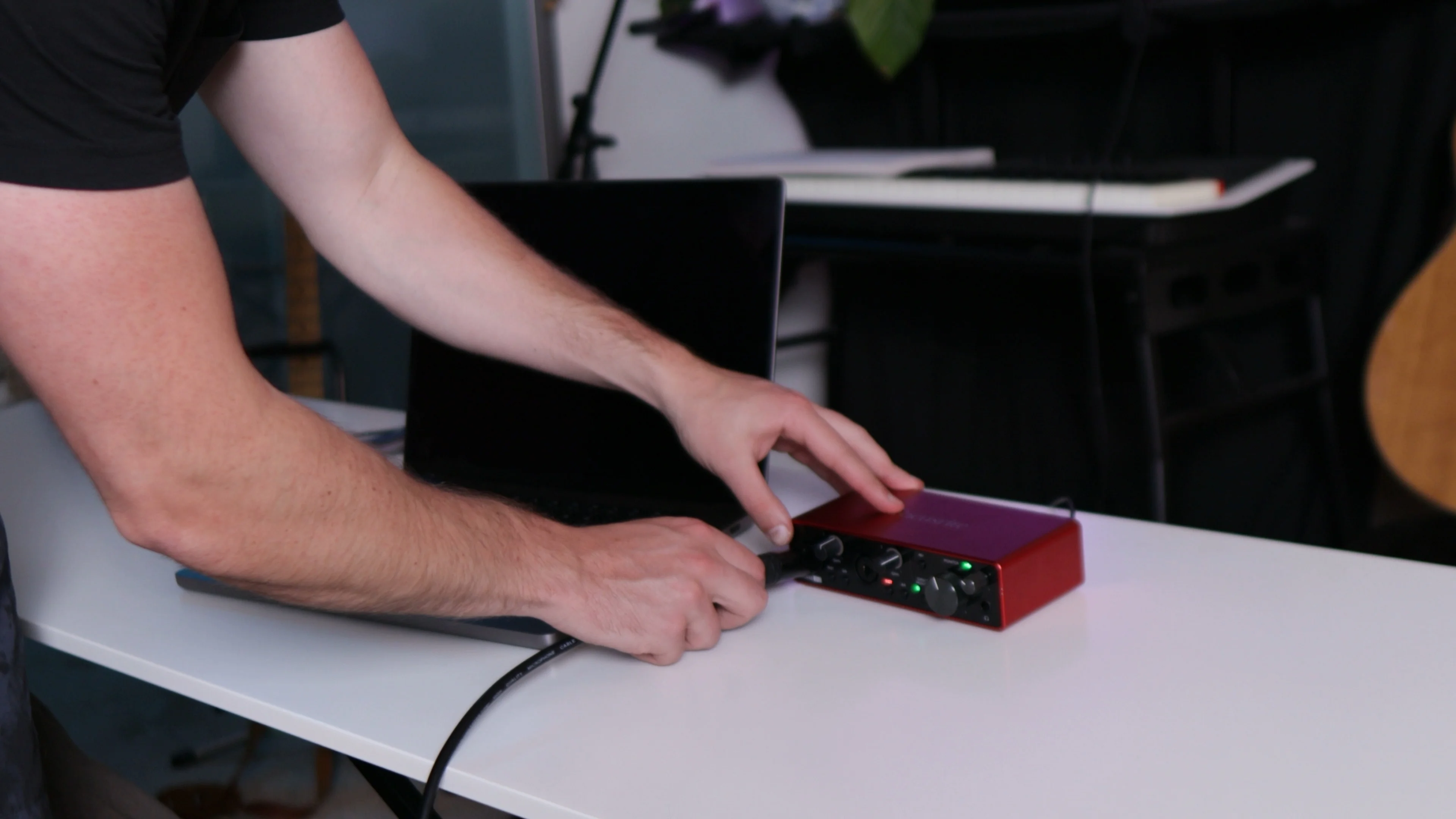 Mattie setting up recording equipment with audio interface, preparing to test vocal processing plugins in home studio