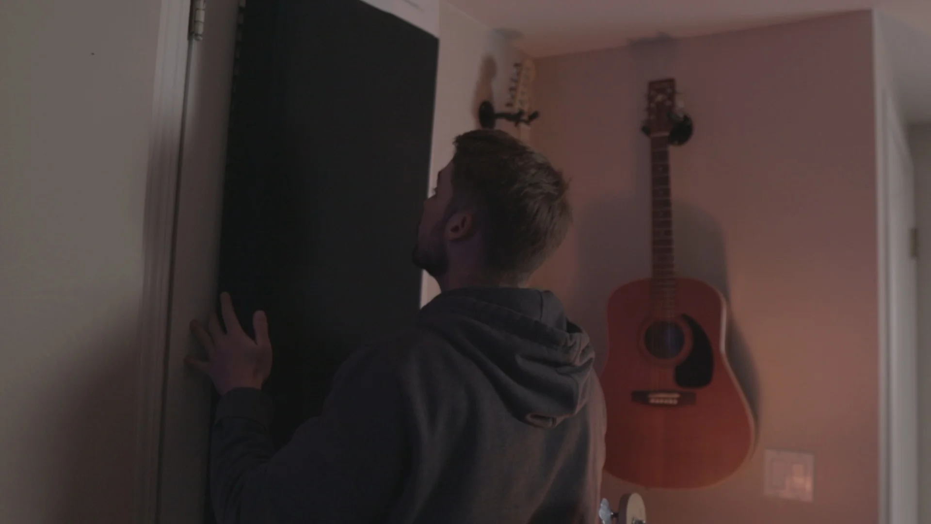 Installing acoustic treatment panels in home studio to create the controlled environment necessary for recording clean background vocals