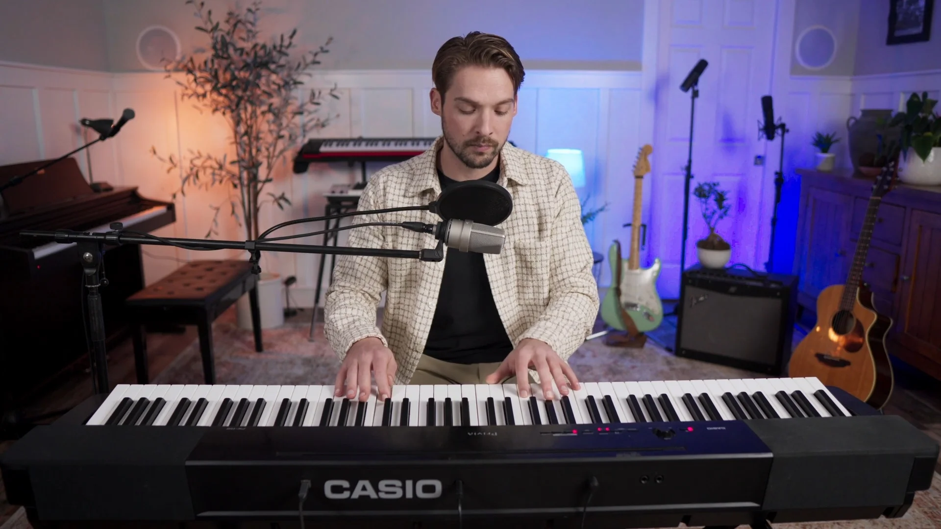 Mattie at keyboard with microphone, demonstrating harmony concepts essential for creating layered vocal arrangements