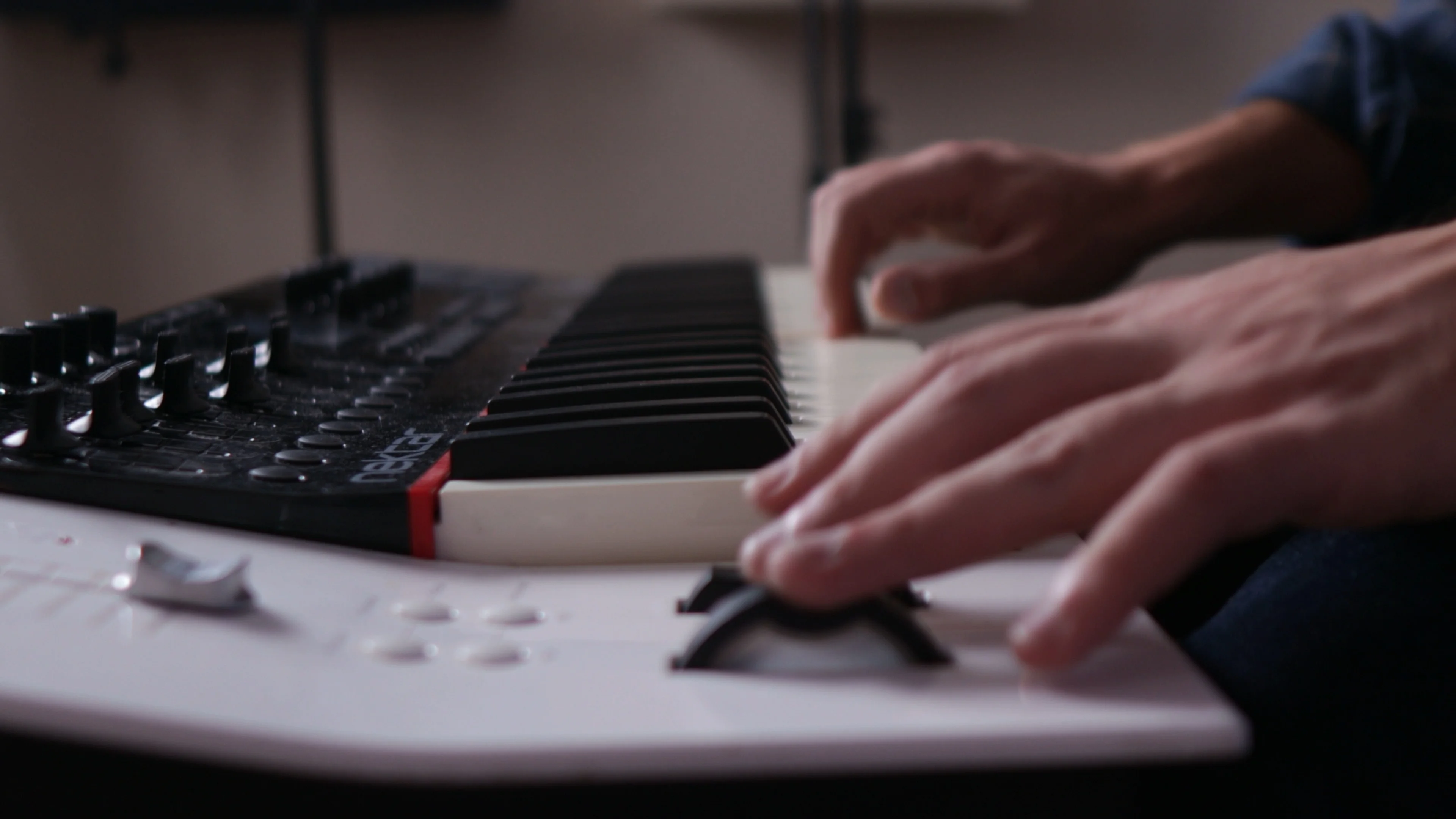 Mattie working with MIDI keyboard controller in home studio, demonstrating the hands-on music production process behind building custom vocal plugins
