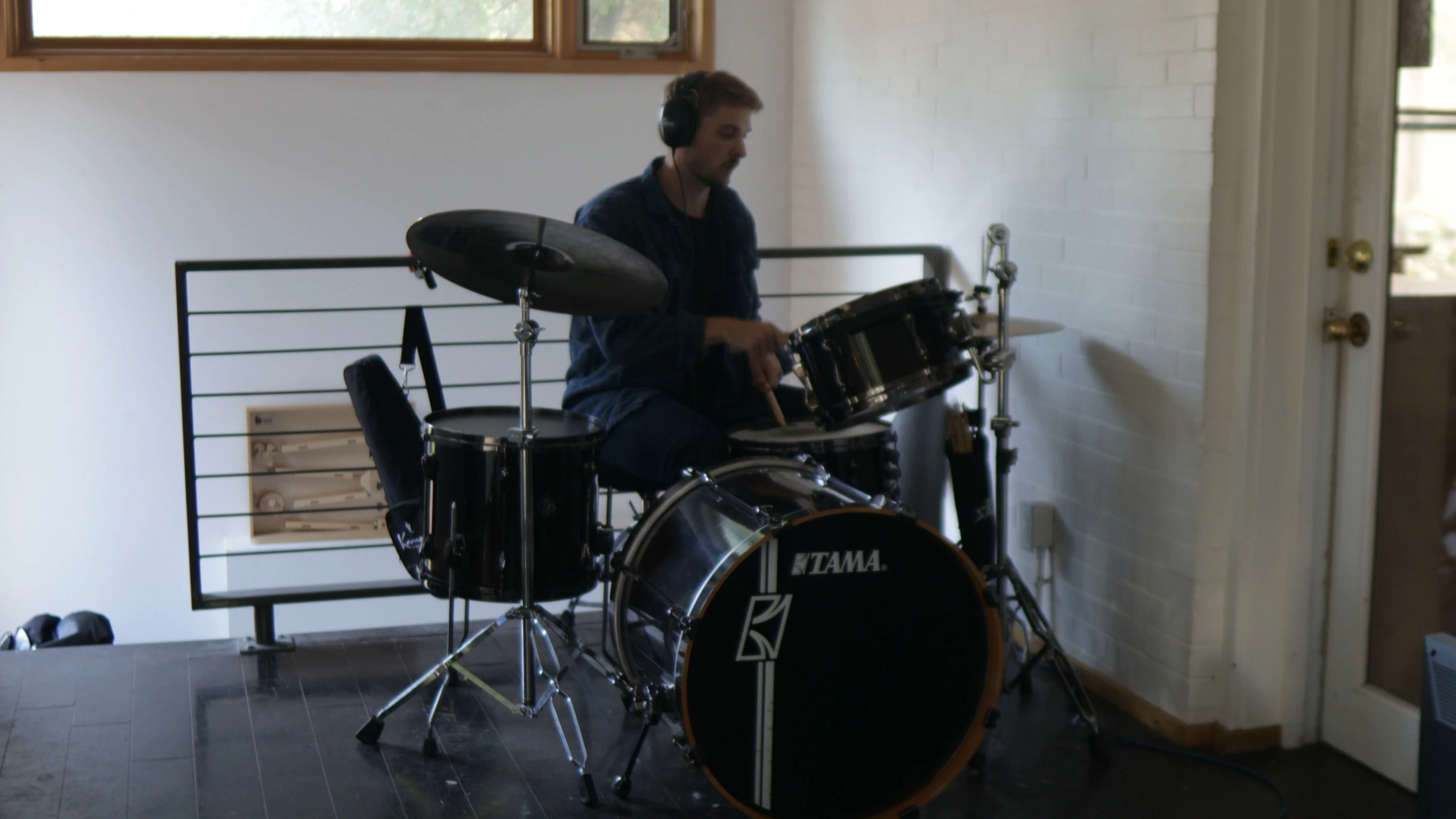 Mattie playing drums in acoustically treated studio, demonstrating the type of recording environment needed for quality vocal compression and mixing