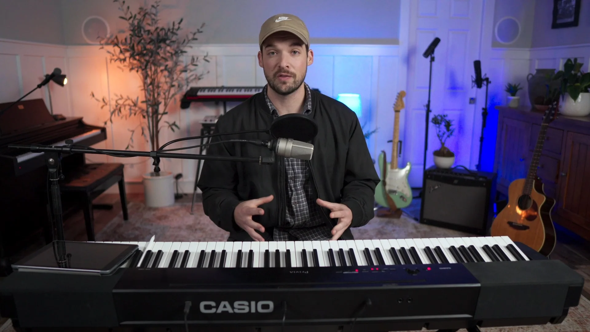 Mattie demonstrating proper microphone positioning and recording technique while speaking into a microphone in a home studio setup
