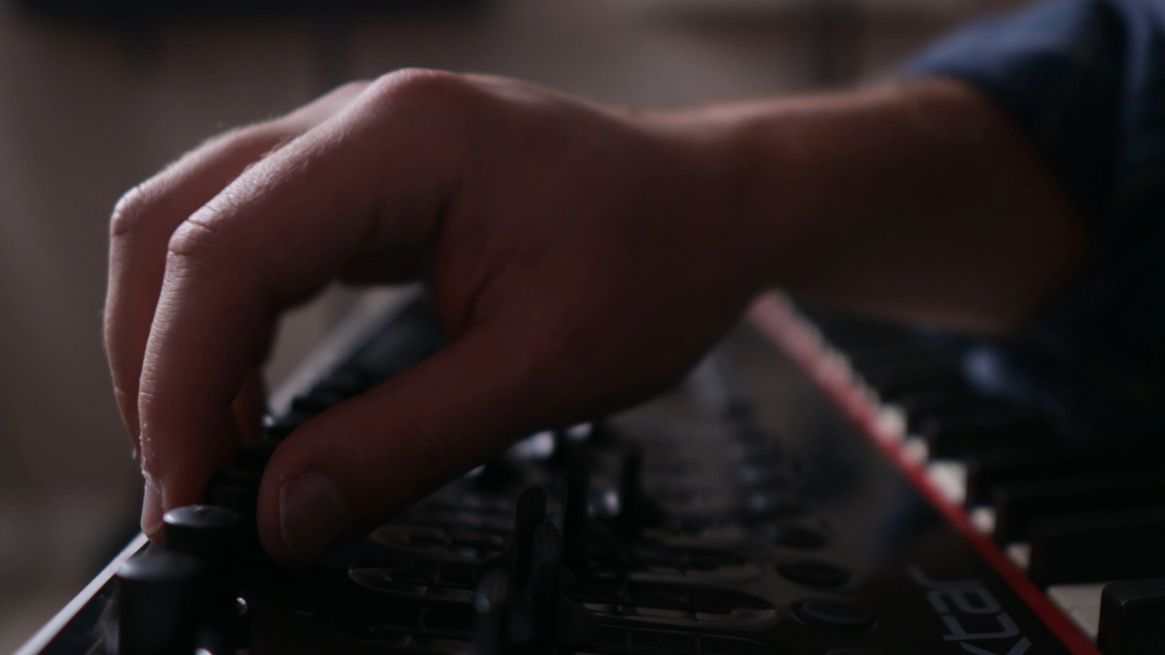 Mattie operating rotary knobs and controls on MIDI keyboard controller to create dynamic automation in music production