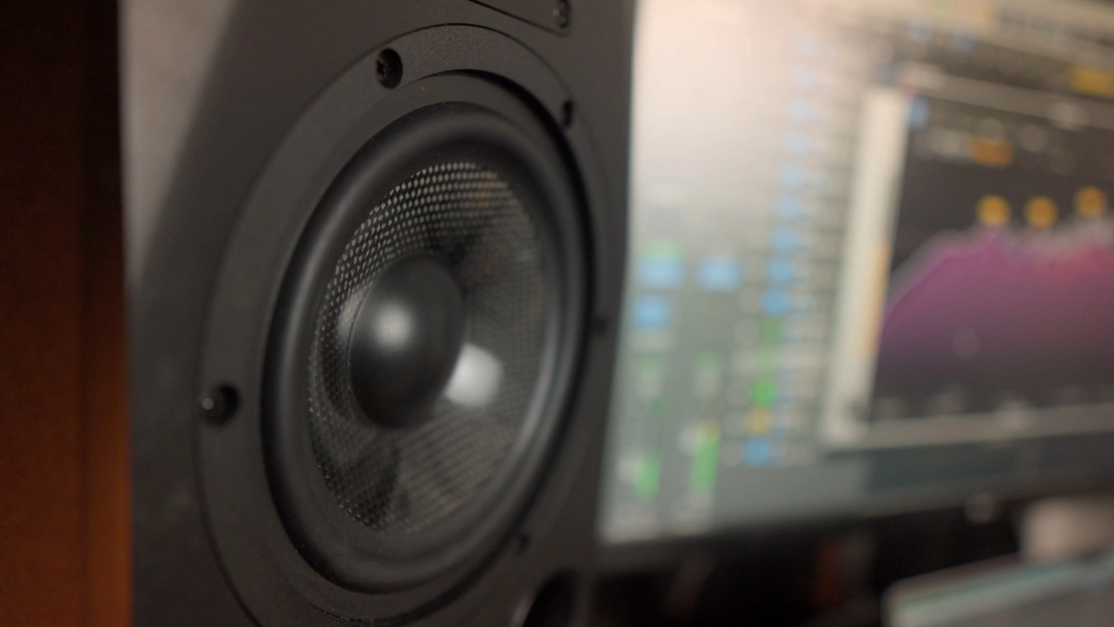 Professional studio monitor speaker with audio software visible on computer screen, essential for accurate stereo panning decisions in mixing